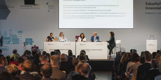 Eine Kongresshalle mit Powerpointpräsentation.