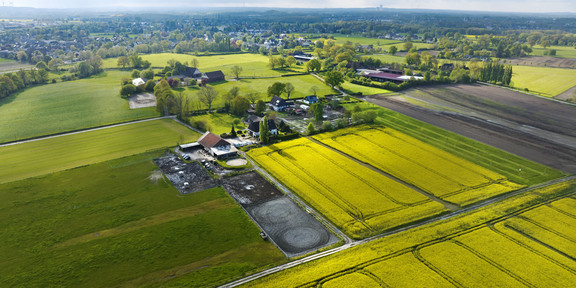 Bild zeigt in Vogelperspektive unterschiedlich bepflanzte Felder mit Häusern und kleineren Siedlungsstrukturen dazwsichen.