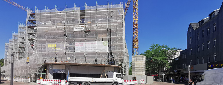 Sichtbar ist ein verhülltes Kaufhaus, das zu dem Zeitpunkt umgebaut wird. Es handelt sich um das alte Hertie-Kaufhaus in Herne.