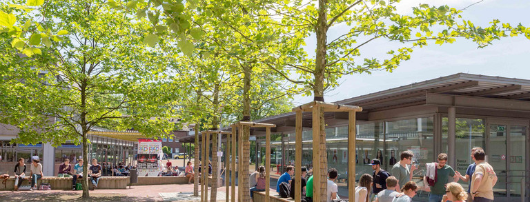 Dieses Bild zeigt den Rudolph-Chaudoire-Pavillion auf dem Campus Süd im Sommer mit einigen Studierenden im Vordergrund.