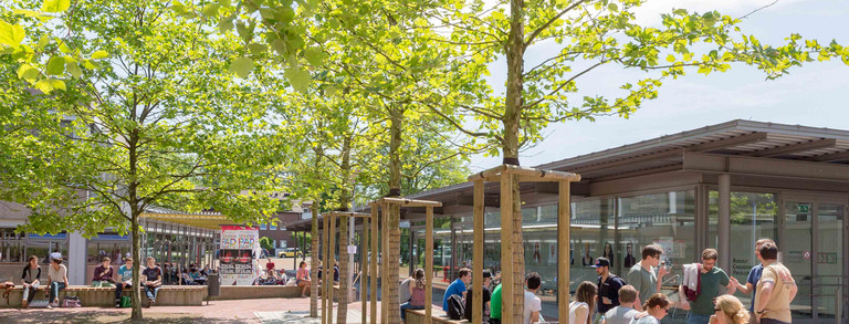 Rudolph-Chaudoire-Pavillion auf dem Campus Süd Dieses Bild zeigt den Rudolph-Chaudoire-Pavillion auf dem Campus Süd im Sommer mit einigen Studierenden im Vordergrund.